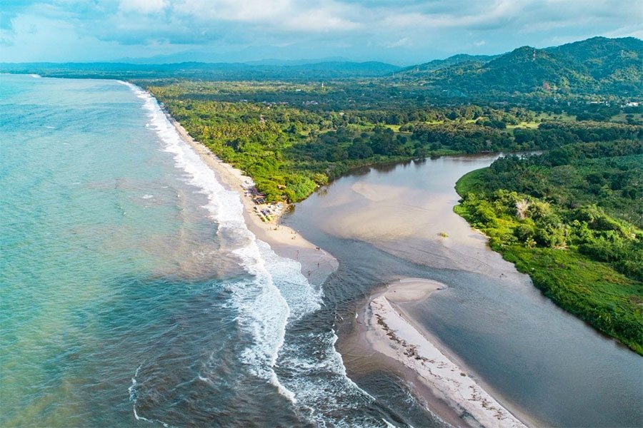 Vista aérea de la playa de Palomino y la desembocadura del río entre la selva, La Guajira, Colombia