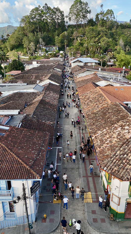 Calle principal de Salento con casas de colores y montañas cafeteras al fondo